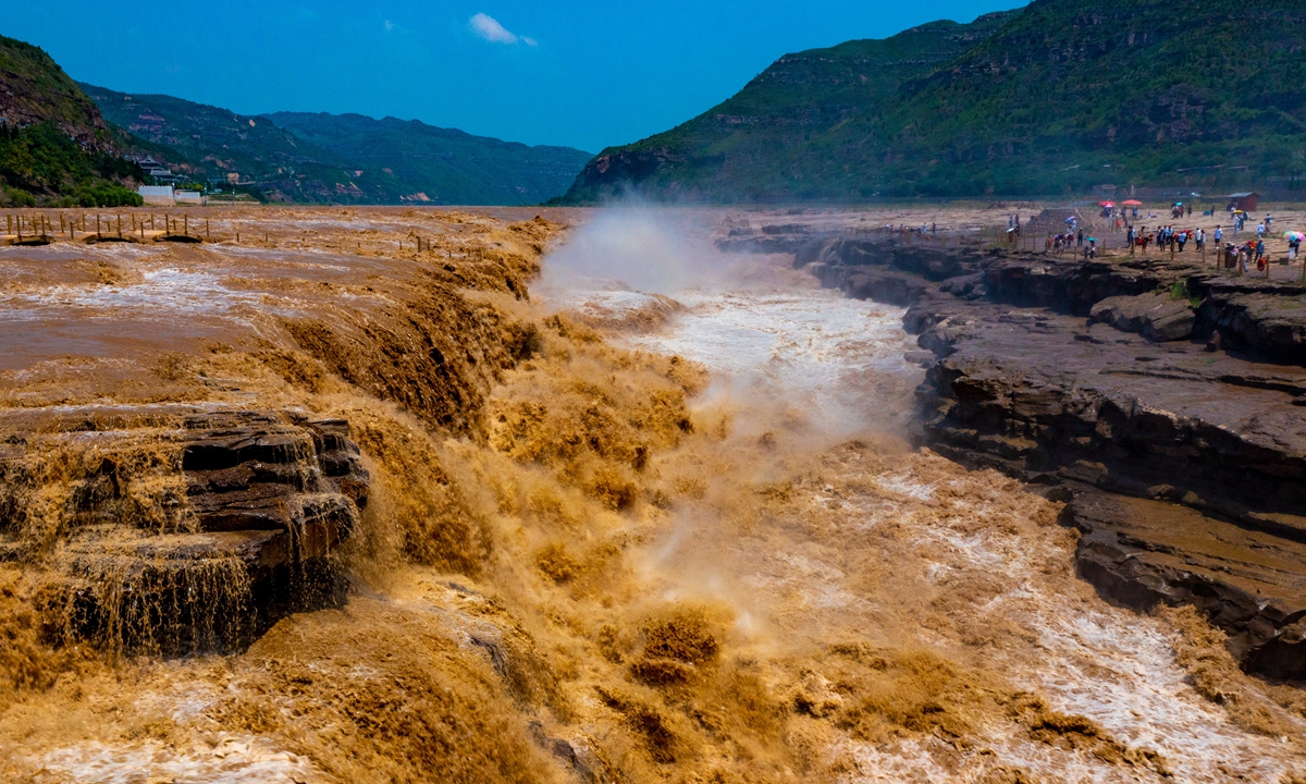 A drone picture taken on July 4, 2022 shows the Hukou Waterfall, the largest waterfall on the Yellow River, as it gushes through the middle of the Qinjin Grand Canyon. Tourists flock to see its famous golden color caused by the sediment carried by the river during the summer flood peak. Photo: cnsphoto