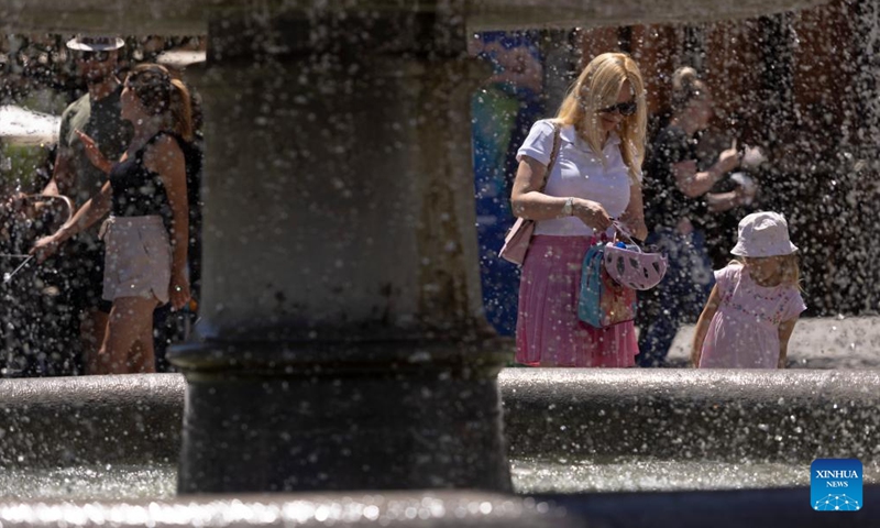 People rest by a fountain in Ljubljana, capital of Slovenia, July 3, 2022. Slovenia continues to experience high temperatures due to a summer heat wave.