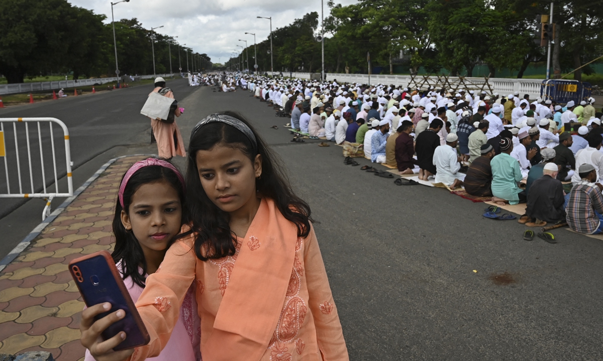 Girls take selfies as Muslims offer Eid al-Adha prayers, the feast of the sacrifice marking the end of the Hajj pilgrimage to Mecca and commemorating Prophet Abraham's readiness to sacrifice his son to show obedience to Allah, in Kolkata, India on July 10, 2022. Photo: AFP