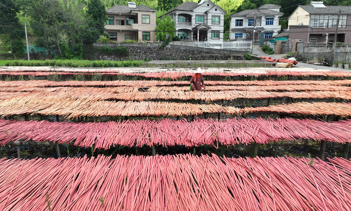 A farmer dries processed bamboo silk in Anji county, East China's Zhejiang Province on July 9, 2022. Anji county, also known as the 