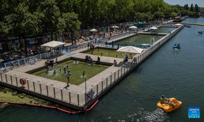 People enjoy the annual Paris Plages city beach event along the banks of the Bassin de la Villette in Paris, France, July 11, 2022. The Paris Plages city beach event is held from July 9 to Aug. 21 this year, offering events and activities on the banks of the Seine and the Bassin de la Villette. (Photo by Aurelien Morissard/Xinhua)