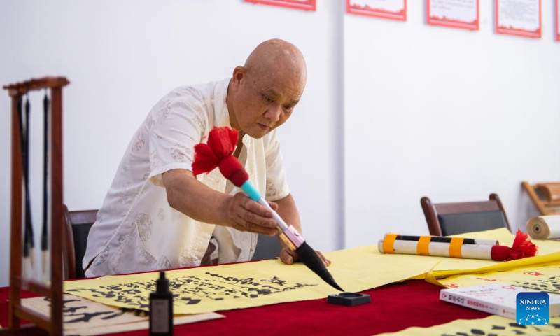 A senior citizen practices calligraphy at a community-based day-care center in Hanshou County, central China's Hunan Province, July 20, 2022. (Xinhua/Chen Sihan)