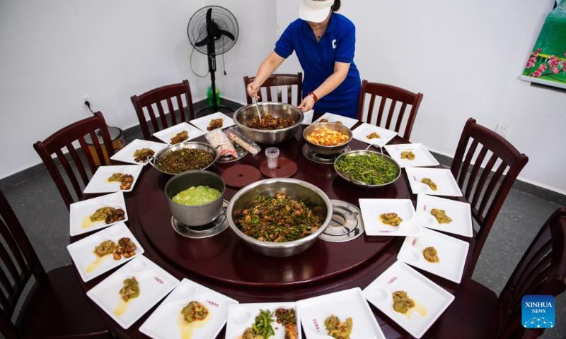 A staff member distributes food for senior citizens at a community-based day-care center in Hanshou County, central China's Hunan Province, July 20, 2022. (Xinhua/Chen Sihan)