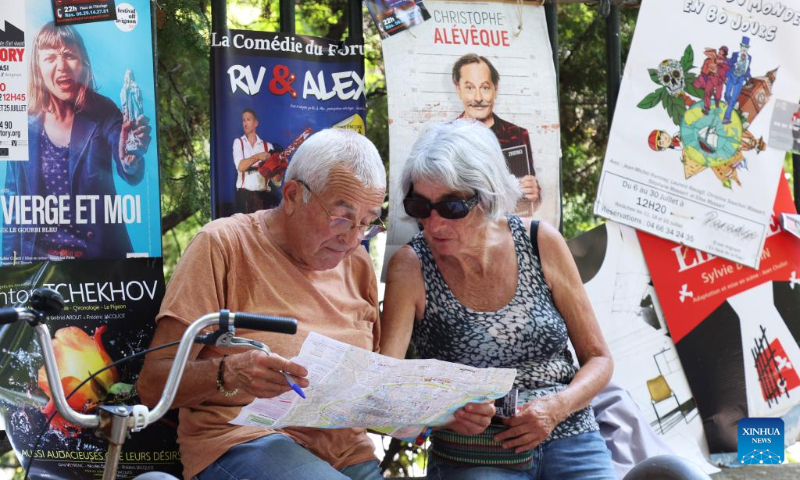 A couple read a city map on the street during the 76th Festival d'Avignon in Avignon, France, July 19, 2022. (Xinhua/Gao Jing)