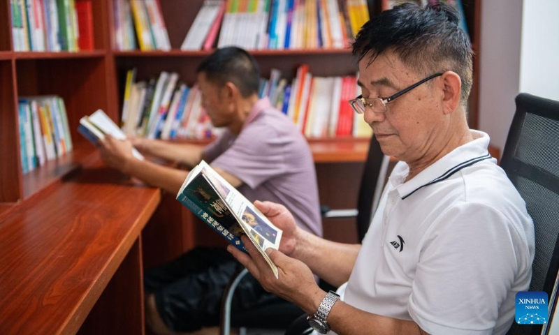 Senior citizens read books at a community-based day-care center in Hanshou County, central China's Hunan Province, July 20, 2022. (Xinhua/Chen Sihan)