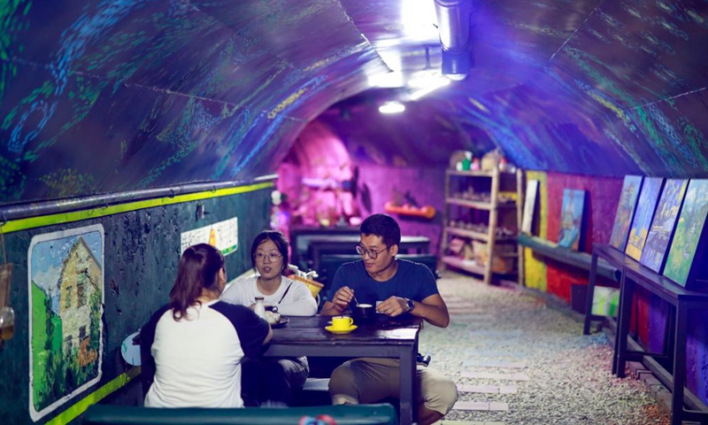 Cafe owner Chen Huanwen (R, back) chats with customers in Jiulongpo District of southwest China's Chongqing, July 11, 2022. As Chongqing is sweltering in a heatwave, locals turn to different places to escape the scorching heat.(Photo: Xinhua)