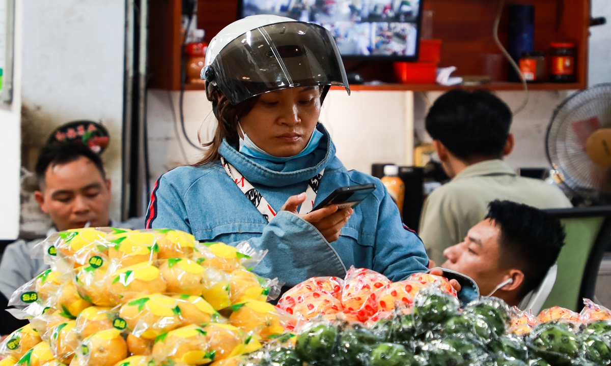 A wholesaler selects fruit in a market in Nanning, South China's Guangxi Zhuang Autonomous Region, on July 14, 2022. Since the opening of a designated regulatory site for imported fruit at the airport in Nanning on May 13, it takes less than a day for fruit from Thailand, Malaysia, Vietnam and other Southeast Asian countries to be picked and sold in China. Photo: VCG