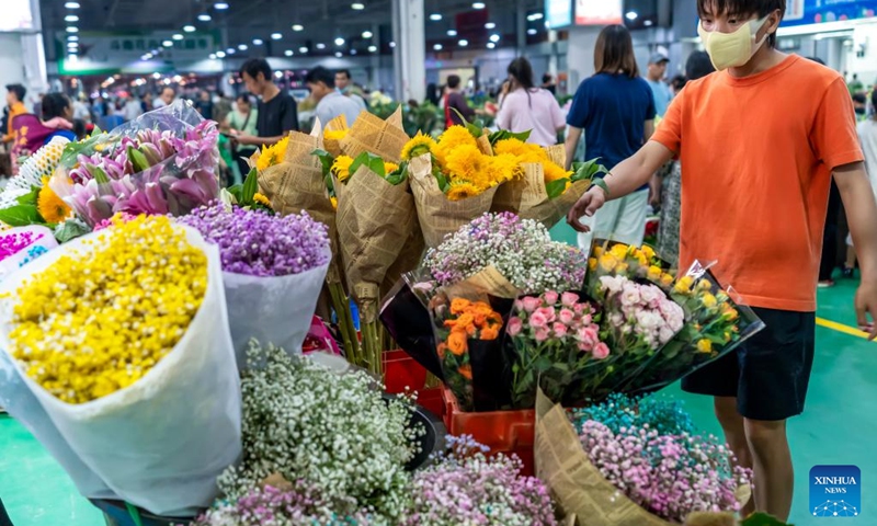 People visit the Kunming Dounan Flower Market at night in southwest China's Yunnan Province, July 12, 2022. Standing as China's largest fresh cut flower market in terms of both trade volume and export value for 23 consecutive years, Dounan has become the largest fresh cut flower trading market in Asia. In recent years, the market has vigorously developed the night economy with flower consumption, tourism and cultural experience.(Photo: Xinhua)