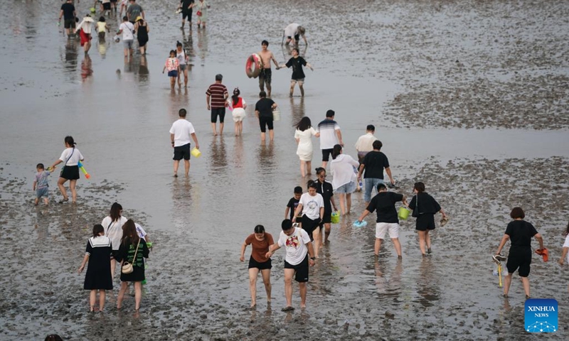 Tourists walk on a beach in Qidong, east China's Jiangsu Province, July 16, 2022.(Photo: Xinhua)