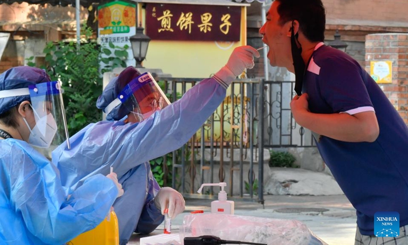 A medical worker takes a swab sample from a citizen for nucleic acid testing at Heping District in Tianjin, north China, July 24, 2022. (Xinhua/Sun Fanyue)