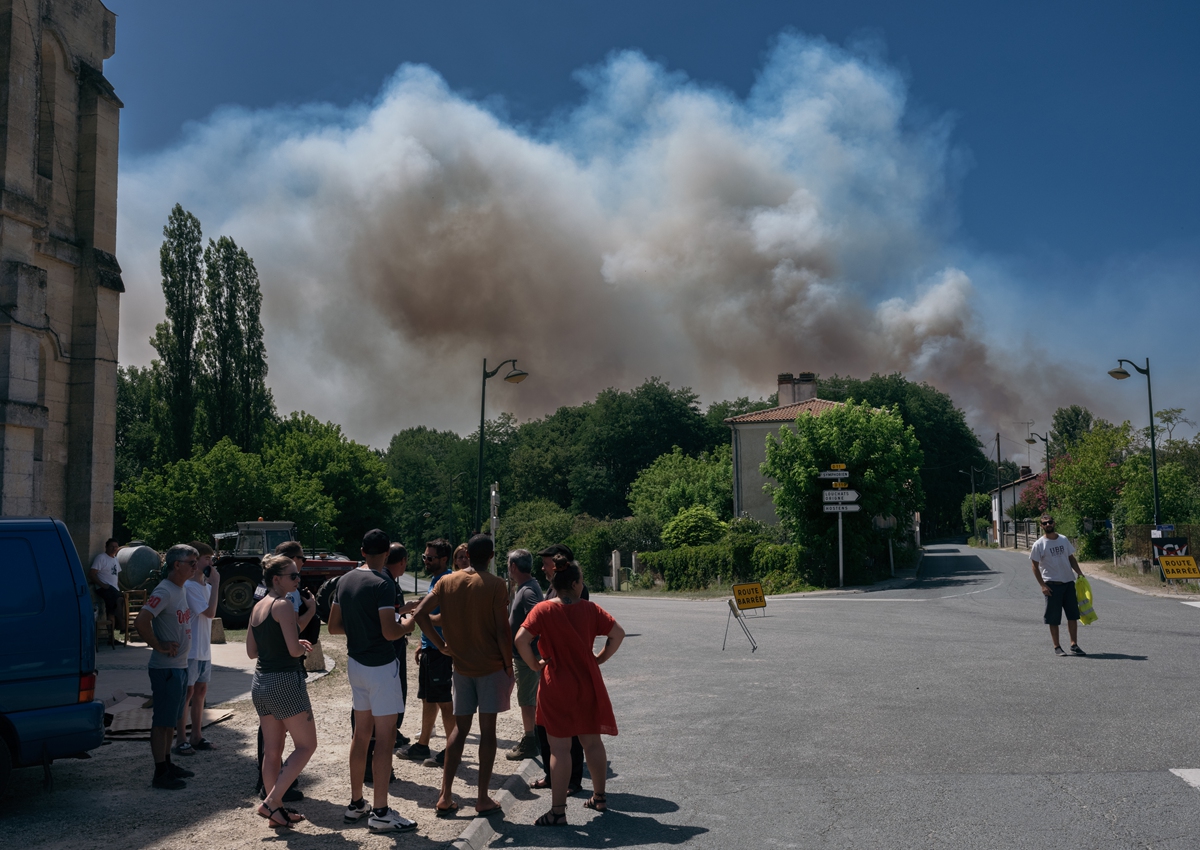 People look on at the smoke from a forest fire in Landiras, France, on July 16, 2022. Photo: VCG