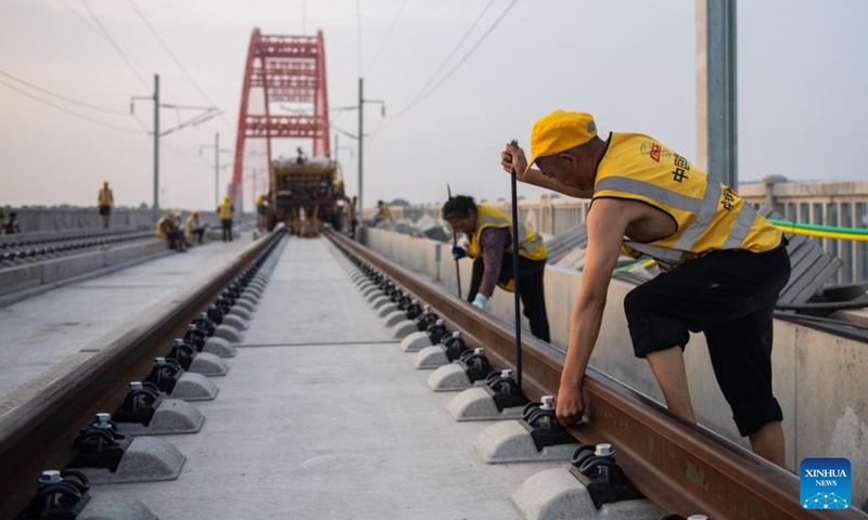 Workers lay tracks at the Zishui super major bridge along Changde-Yiyang-Changsha railway, in central China's Hunan Province, July 18, 2022. The 157-kilometer high-speed railway line, connecting the cities of Changde, Yiyang and Changsha in Hunan Province with a designed speed of 350 kilometers per hour, is an important part in China's high-speed railway network.(Photo: Xinhua)