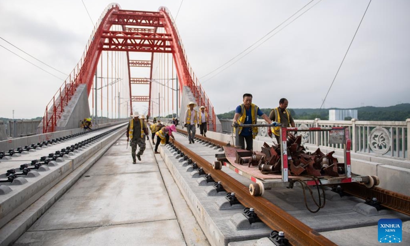 Workers lay tracks at the Zishui super major bridge along Changde-Yiyang-Changsha railway, in central China's Hunan Province, July 18, 2022. The 157-kilometer high-speed railway line, connecting the cities of Changde, Yiyang and Changsha in Hunan Province with a designed speed of 350 kilometers per hour, is an important part in China's high-speed railway network.(Photo: Xinhua)