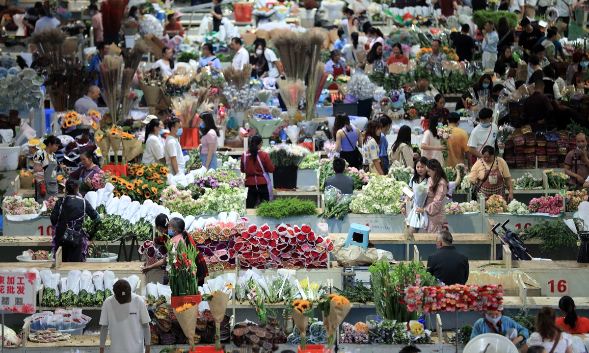 People buy flowers at the Dounan flower market in Kunming, Southwest China's Yunnan Province, on July 17, 2022. Dubbed as the 