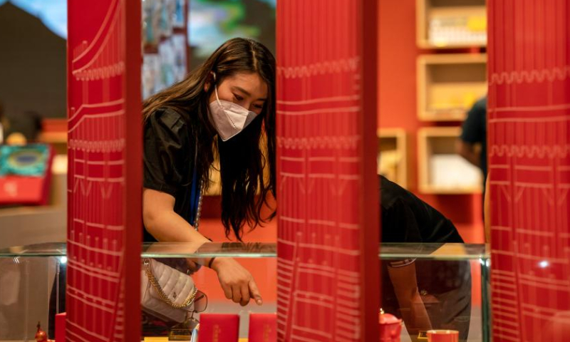 People select products at the 2022 China International Travel Mart (CITM) in Kunming, southwest China's Yunnan Province, July 22, 2022. The 2022 CITM kicked off Friday in Kunming after a hiatus of one year due to the COVID-19 epidemic. Photo: Xinhua