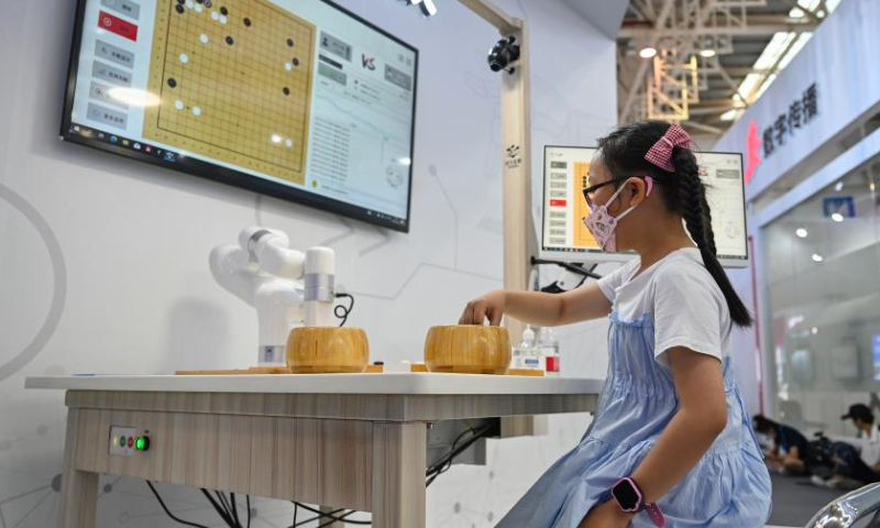 A young visitor plays Go (Weiqi) with an AI robot during a special exhibition of the 5th Digital China Summit in Fuzhou, southeast China's Fujian Province, July 22, 2022. A special exhibition was held here on Friday as part of the 5th Digital China Summit, displaying the latest achievements in building a digital China over the last five years.  Photo: Xinhua