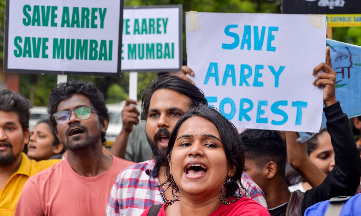 People shout slogans as they hold posters during a protest after the government re-approved of constructing a metro railway train car shed at the Aarey forest which locals call as 