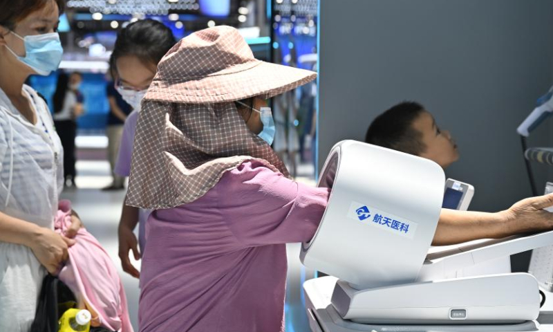 A visitor tries an intelligent health service at a special exhibition of the 5th Digital China Summit in Fuzhou, southeast China's Fujian Province, July 22, 2022. A special exhibition was held here on Friday as part of the 5th Digital China Summit, displaying the latest achievements in building a digital China over the last five years. Photo: Xinhua