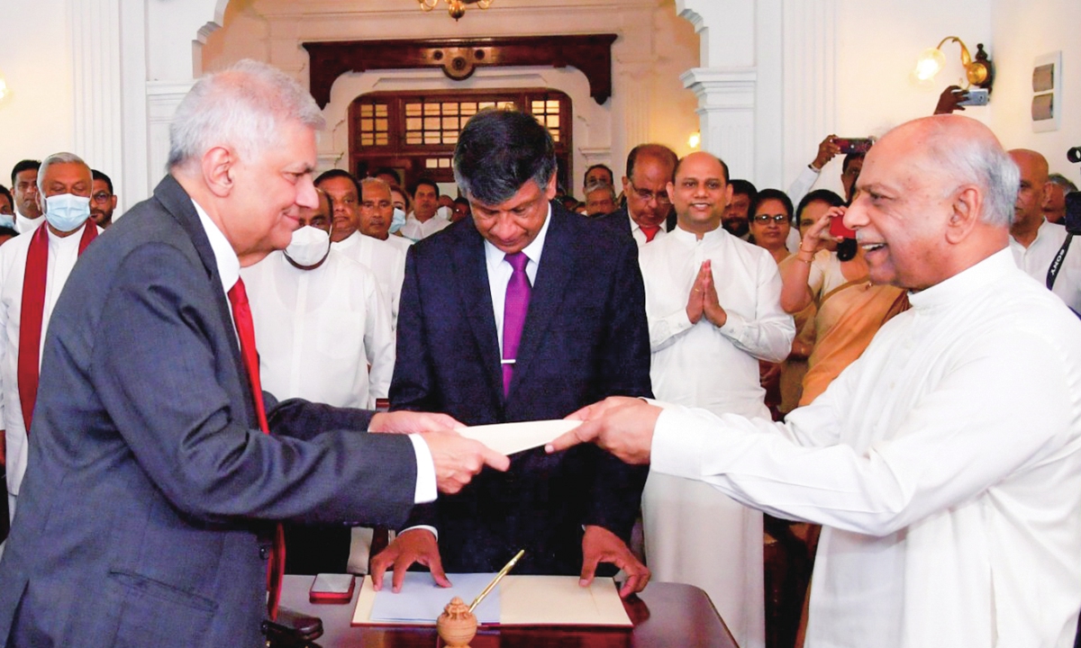 A handout photo made available by the Sri Lankan president's media division shows Dinesh Gunawardena (R) being sworn in as the new prime minister of Sri Lanka in front of President Ranil Wickremesinghe (L) in Colombo, Sri Lanka, on July 22, 2022. Photo: IC