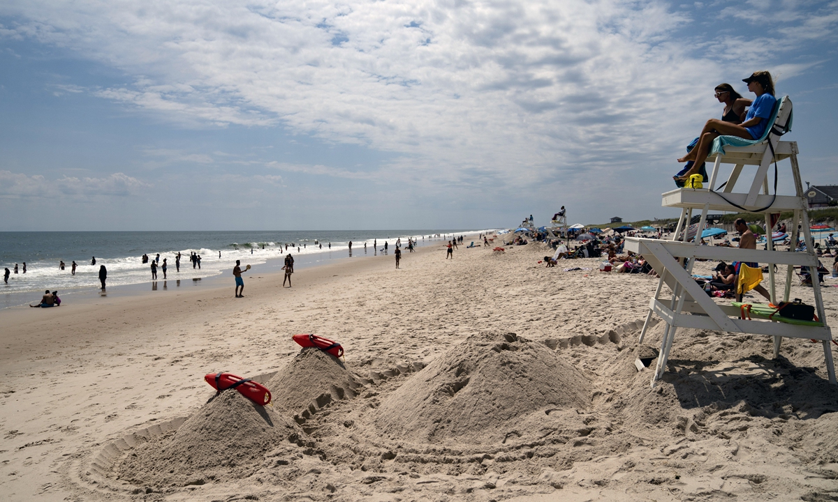 Beachgoers enjoy the surf as lifeguards look on at Smith Point County Park, a Long Island beach where a shark bit a lifeguard 10 days earlier, on July 15, 2022, in Shirley, New York.  Photo: VCG