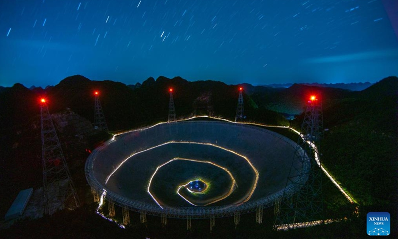 The long-time exposure photo taken on July 24, 2022 shows China's Five-hundred-meter Aperture Spherical Radio Telescope (FAST) under maintenance in southwest China's Guizhou Province. Using FAST, or the China Sky Eye, scientists have identified over 660 new pulsars. (Xinhua/Ou Dongqu)