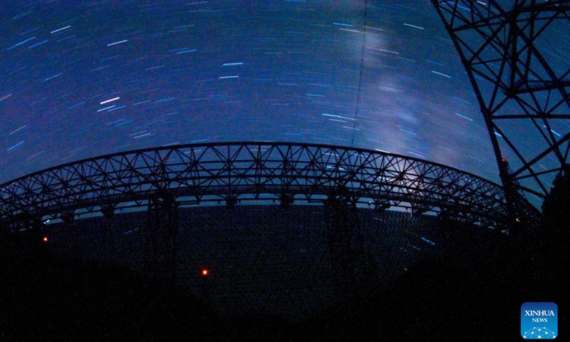 The long-time exposure photo taken on July 25, 2022 shows China's Five-hundred-meter Aperture Spherical Radio Telescope (FAST) under maintenance in southwest China's Guizhou Province. Using FAST, or the China Sky Eye, scientists have identified over 660 new pulsars. (Xinhua/Ou Dongqu)