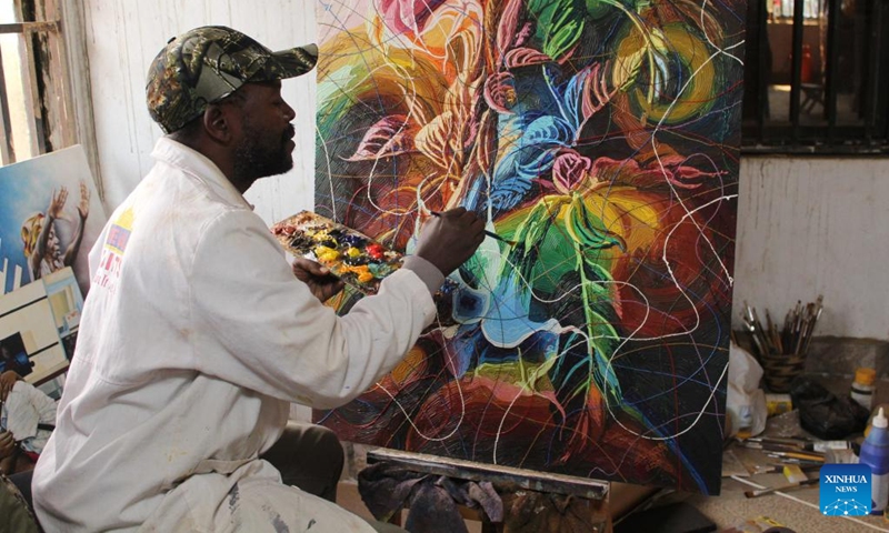 Artist Edward Kamugisha Ssajjabbi is seen working on a painting at his studio house in Kabale, Uganda, July 22, 2022.(Photo: Xinhua)