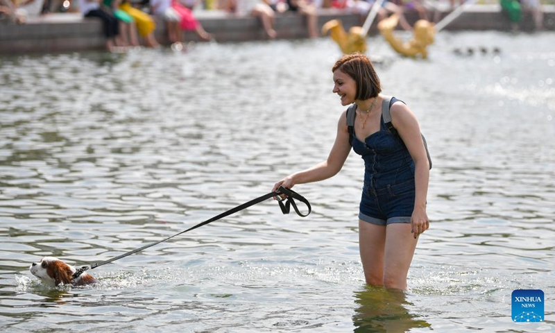 A woman and a dog are seen in a fountain in Moscow, Russia, on July 27, 2022.(Photo: Xinhua)