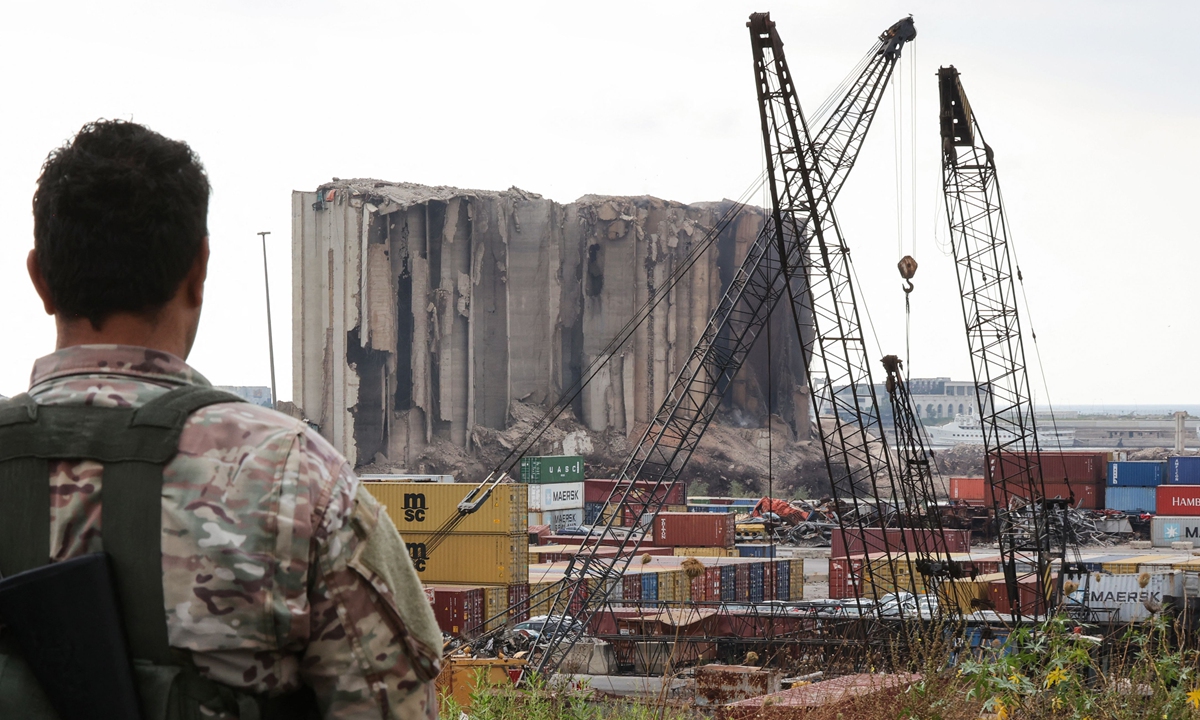 A security officer looks at the heavily damaged grain silos in the port of Lebanese capital Beirut, on July 31, 2022, following a partial collapse due to an ongoing fire since the beginning of July. Photo: VCG