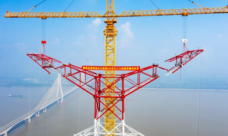 Aerial photo taken on Aug. 1, 2022 shows the construction site of a long span transmission tower of Baihetan-Zhejiang ultra-high-voltage (UHV) power transmission project by the Yangtze River in Chizhou, east China's Anhui Province. Construction of the main structure of a 345-meter-high long span transmission tower of Baihetan-Zhejiang UHV power transmission project was completed here Monday. (Photo by Zheng Xianlie/Xinhua)