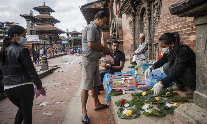 A man buys posters of naga (snake) on the occasion of Naga Panchami in Lalitpur, Nepal, Aug. 1, 2022. Naga Panchami is a festival of traditional worship of Naga or snake deities.(Photo: Xinhua)