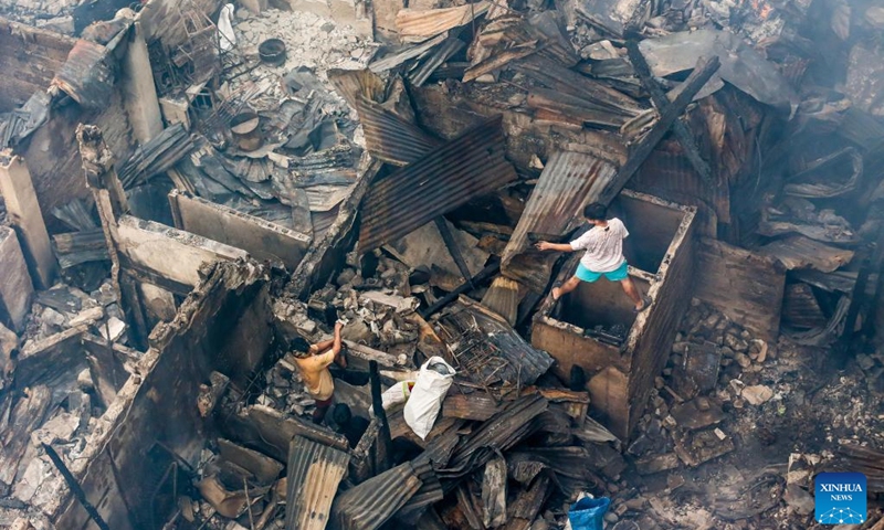 Residents search for reusable materials from their charred homes after a fire at a residential area in Manila, the Philippines, Aug. 3, 2022. Some 500 families lost their homes in the fire, according to local media.(Photo: Xinhua)