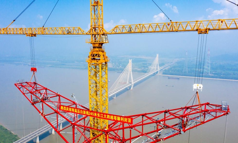 Aerial photo taken on Aug. 1, 2022 shows the construction site of a long span transmission tower of Baihetan-Zhejiang ultra-high-voltage (UHV) power transmission project by the Yangtze River in Chizhou, east China's Anhui Province. Construction of the main structure of a 345-meter-high long span transmission tower of Baihetan-Zhejiang UHV power transmission project was completed here Monday. (Photo by Zheng Xianlie/Xinhua)