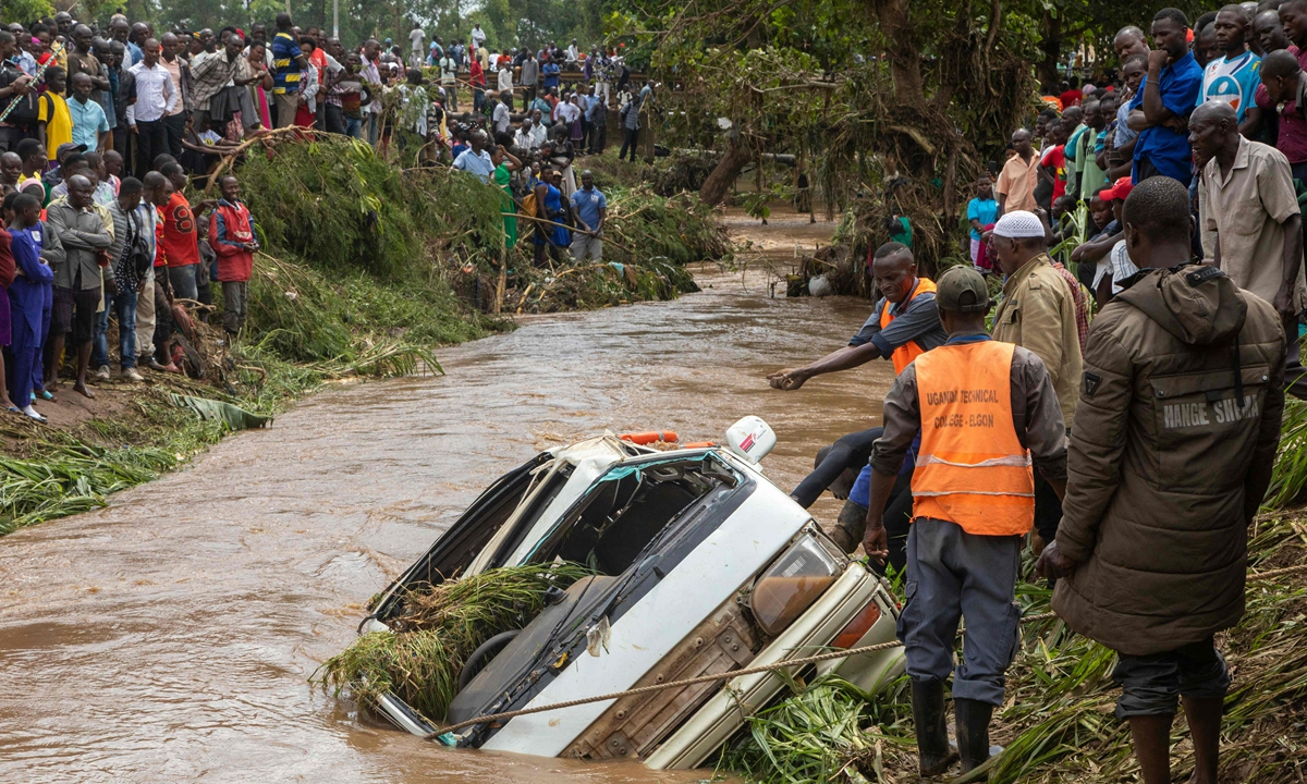 Villagers try to retrieve the bodies of 14 people from a minibus in the River Nabuyonga in Namakwekwe, Uganda, on August 1, 2022. Floods in parts of eastern Uganda resulting from torrential rains have killed at least 24 people, the government and Uganda Red Cross said. Photo: VCG