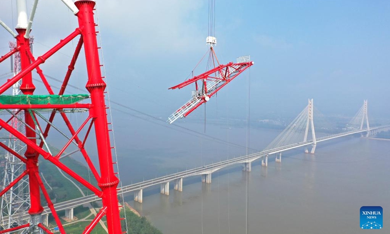 Aerial photo taken on Aug. 1, 2022 shows the construction site of a long span transmission tower of Baihetan-Zhejiang ultra-high-voltage (UHV) power transmission project by the Yangtze River in Chizhou, east China's Anhui Province. Construction of the main structure of a 345-meter-high long span transmission tower of Baihetan-Zhejiang UHV power transmission project was completed here Monday. (Photo by Zhao Xianfu/Xinhua)