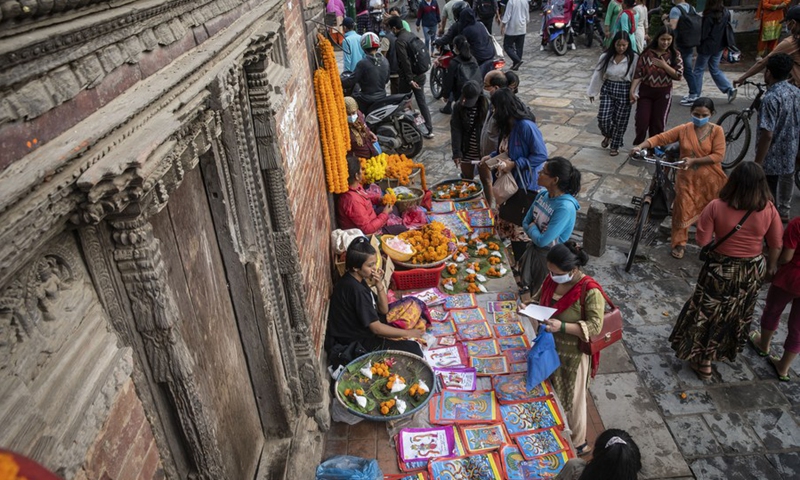 People buy posters of Naga (snake) on the occasion of Naga Panchami in Lalitpur, Nepal, Aug. 1, 2022. Naga Panchami is a festival of traditional worship of Naga or snake deities.(Photo: Xinhua)