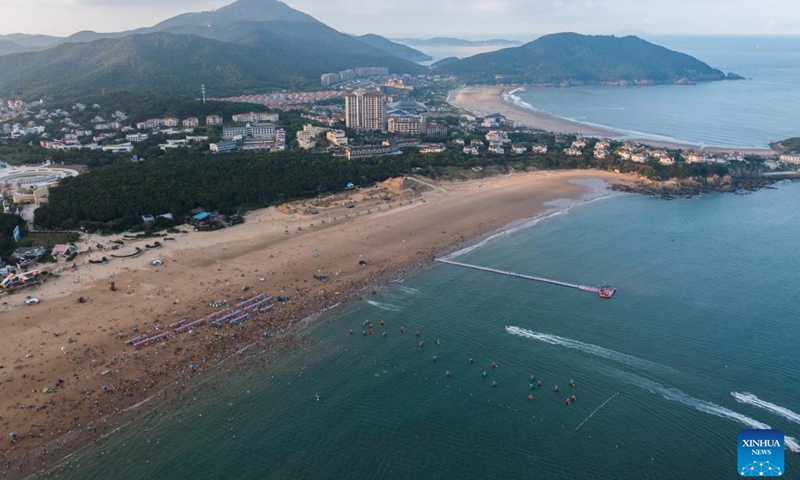 Aerial photo taken on Aug. 2, 2022 shows tourists enjoying seaside time in Zhujiajian scenic spot in Zhoushan, east China's Zhejiang Province. Zhujiajian scenic spot has provided various seaside entertainments for tourists to boost tourism during the summer vacation.(Photo: Xinhua)