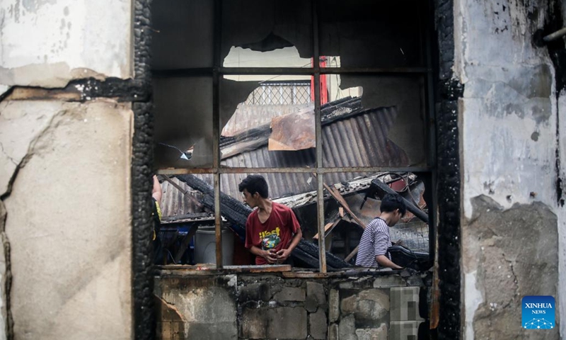 Residents search for reusable materials from their charred homes after a fire at a residential area in Manila, the Philippines, Aug. 3, 2022. Some 500 families lost their homes in the fire, according to local media.(Photo: Xinhua)