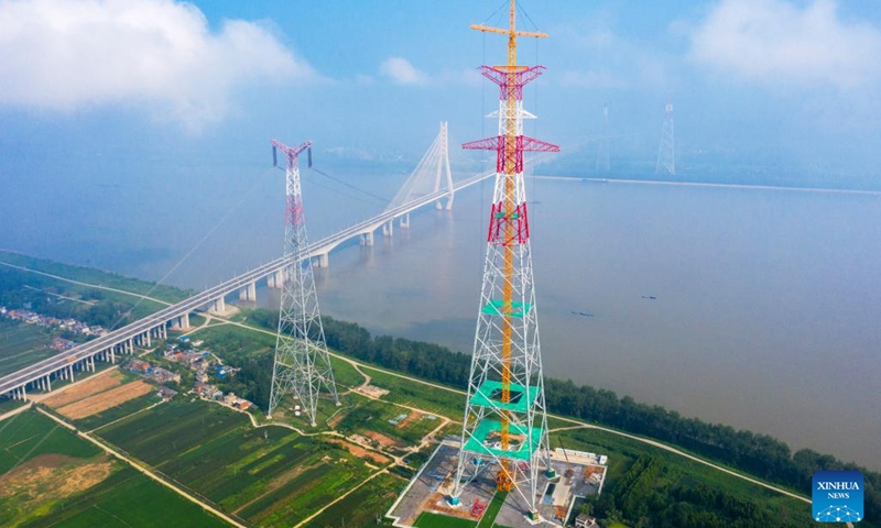 Aerial photo taken on Aug. 1, 2022 shows a long span transmission tower of Baihetan-Zhejiang ultra-high-voltage (UHV) power transmission project by the Yangtze River in Chizhou, east China's Anhui Province. Construction of the main structure of a 345-meter-high long span transmission tower of Baihetan-Zhejiang UHV power transmission project was completed here Monday. (Photo by Zheng Xianlie/Xinhua)