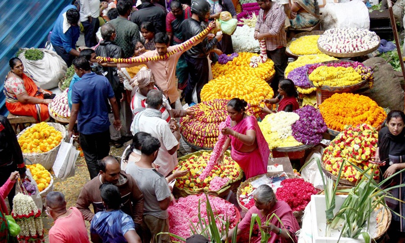 Indian people of Hindu religion shop for flowers at a wholesale market in Bangalore, India, Aug. 4, 2022.(Photo: Xinhua)