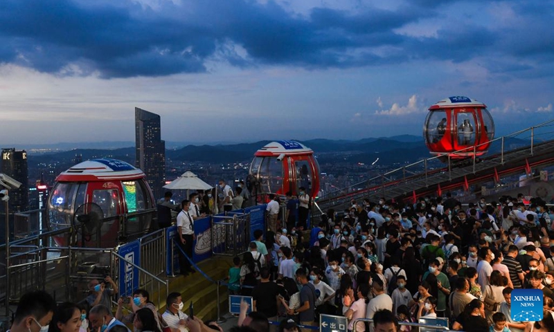 Tourists visit a lookout deck at the top of the Canton Tower, a landmark in Guangzhou, south China's Guangdong Province, Aug. 7, 2022. Tourist attractions that blend modernity with history are gaining popularity among visitors to Guangzhou, one of the top summer travel destinations in China.((Photo: Xinhua)