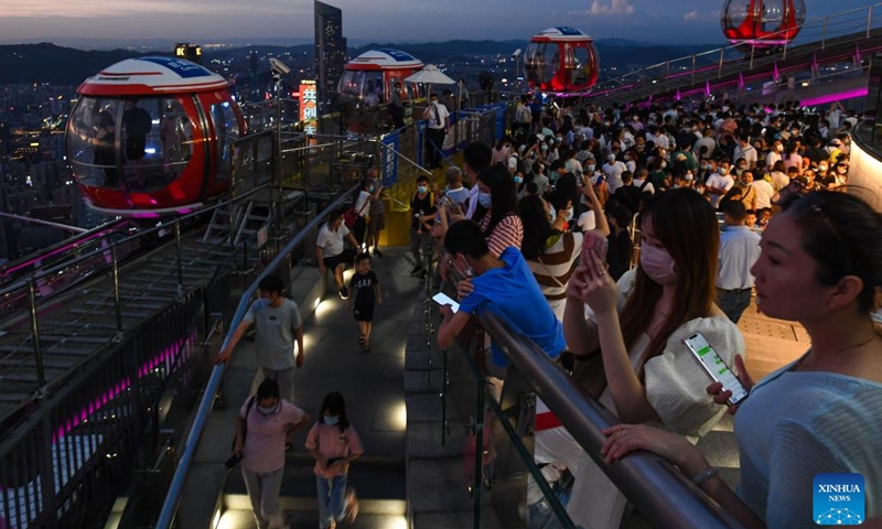 Tourists visit a lookout deck at the top of the Canton Tower, a landmark in Guangzhou, south China's Guangdong Province, Aug. 7, 2022. Tourist attractions that blend modernity with history are gaining popularity among visitors to Guangzhou, one of the top summer travel destinations in China.((Photo: Xinhua)