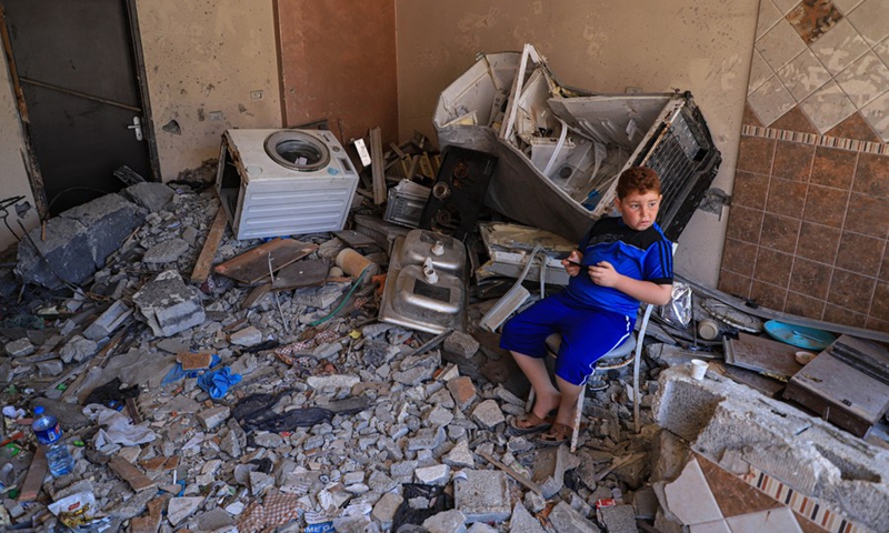 A relative of Hassan Shamalakh, 69, stand over the rubbles of a house, in Gaza City, on Aug. 14, 2022.(Photo: Xinhua)