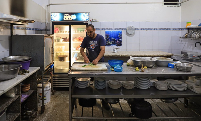 A worker cooks at Mohammed Abu Hasira restaurant, which damaged by Israeli airstrike, in Gaza City, on Aug. 8, 2022. (Photo: Xinhua)