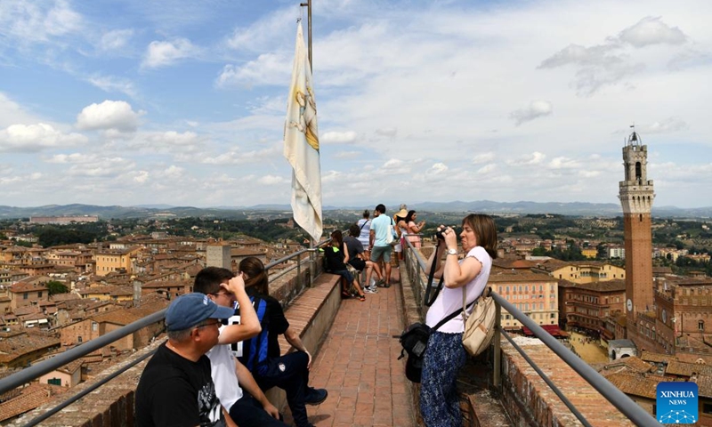 Tourists enjoy the city view in Siena, Italy, Aug. 15, 2022. Siena is famous for its medieval cityscape and the horse race Palio. The historic center of Siena was inscribed on the UNESCO World Heritage List in 1995.(Photo: Xinhua)