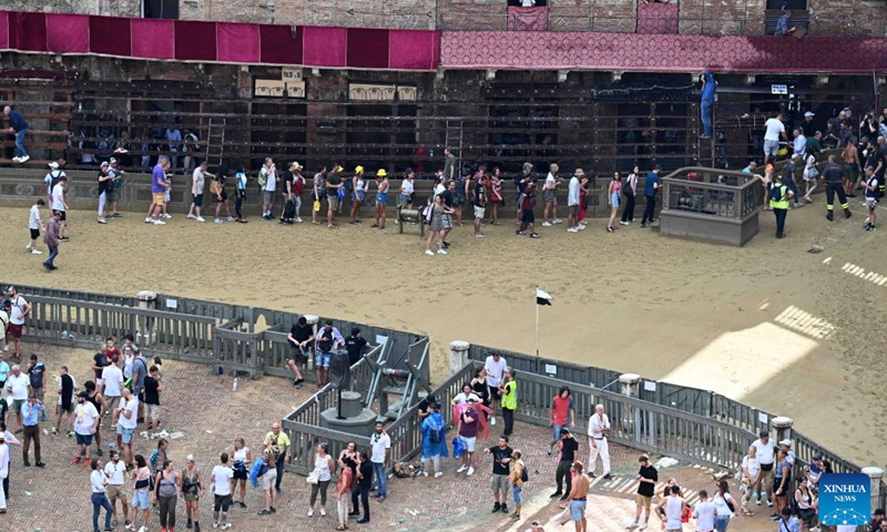 Spectators leave after the suspension of the horse race Palio in Siena, Italy, Aug. 16, 2022. The horse race Palio has been postponed to Aug. 17 due to the rain. The historical horse race Palio is held again this year after a two-year pause because of the COVID-19 pandemic. (Photo by Alberto Lingria/Xinhua)