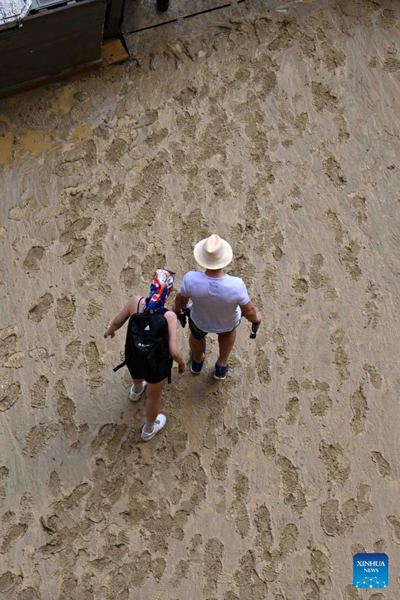 Spectators leave after the suspension of the horse race Palio in Siena, Italy, Aug. 16, 2022. The horse race Palio has been postponed to Aug. 17 due to the rain. The historical horse race Palio is held again this year after a two-year pause because of the COVID-19 pandemic. (Photo by Alberto Lingria/Xinhua)