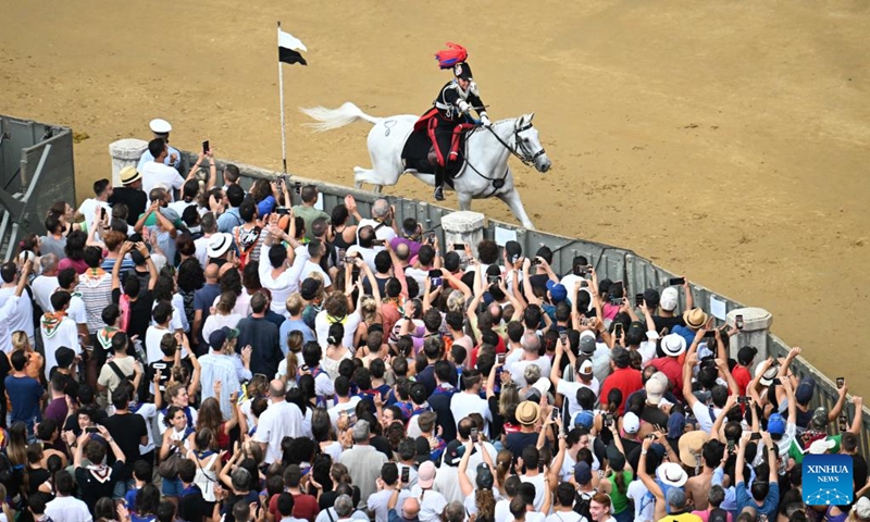 An Italian Carabinieri performs before the suspension of the horse race Palio in Siena, Italy, Aug. 16, 2022. The horse race Palio has been postponed to Aug. 17 due to the rain. The historical horse race Palio is held again this year after a two-year pause because of the COVID-19 pandemic. (Photo by Alberto Lingria/Xinhua)