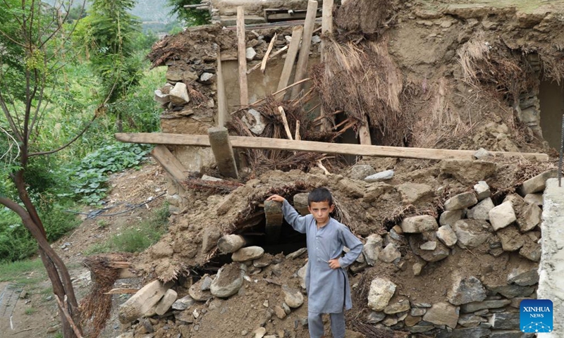 A boy stands in front of the rubbles of houses destroyed by flood in Nuristan province, Afghanistan, Aug. 18, 2022.(Photo: Xinhua)