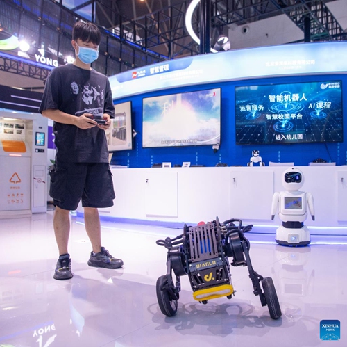 A staff member operates a robot during the Smart China Expo 2022 in southwest China's Chongqing, Aug. 22, 2022. The Smart China Expo 2022 opened Monday in southwest China's Chongqing Municipality, attracting over 500 exhibitors from home and abroad to showcase their latest intelligent technology achievements.(Photo: Xinhua)